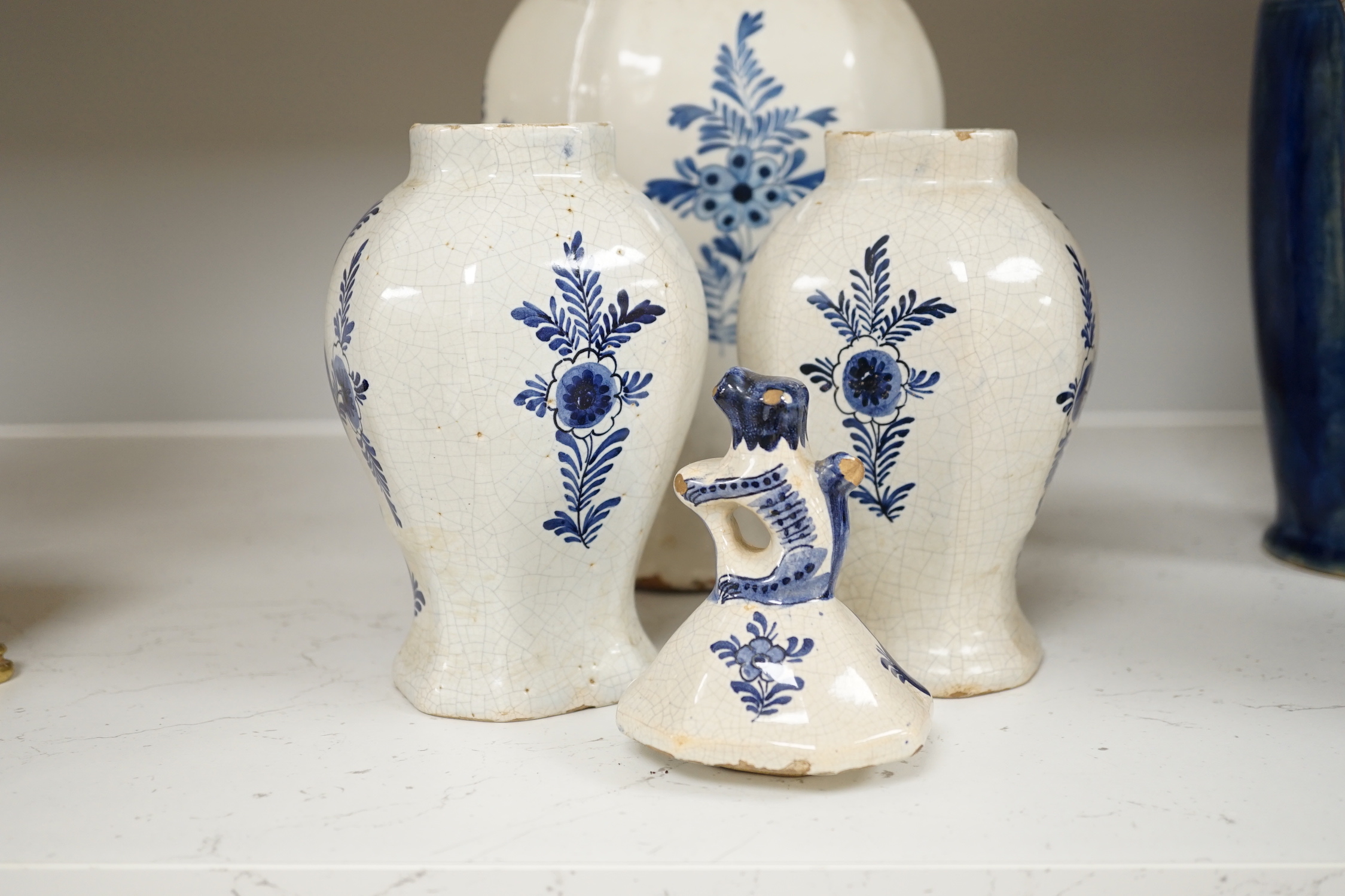 An 18th century Delft blue and white vase and a pair of later Delft vases and covers, tallest 23.5cm